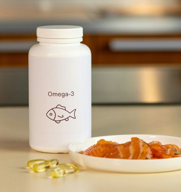 Balancing Omega-3 Supplements and Salmon for Optimal Men's Health Omega-3 supplements and fresh salmon on a table, highlighting natural sources for men's health