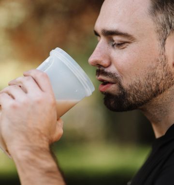 Man is drinking a protein shake to lose weight Man is drinking a protein shake