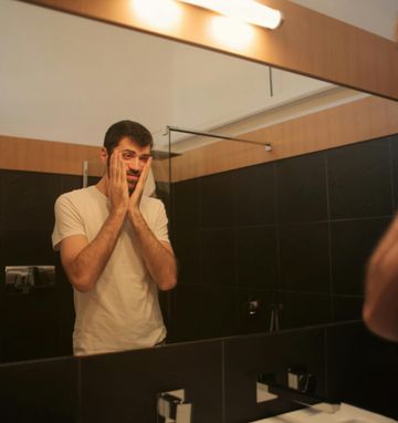 Man Overcoming Fatigue with Supplements Exhausted man researching supplements to combat fatigue and boost energy levels